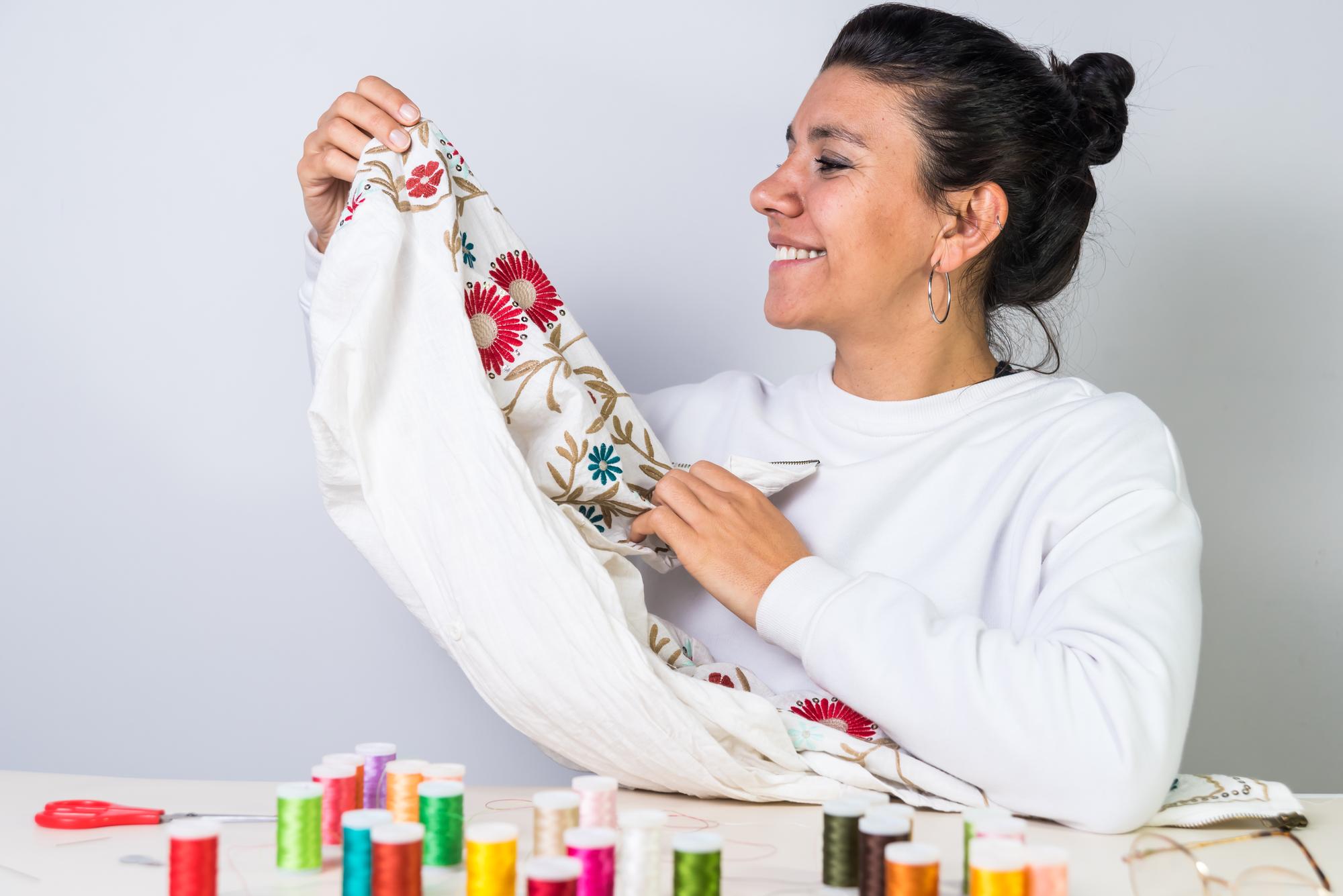 Artist sewing embroidery sample in studio