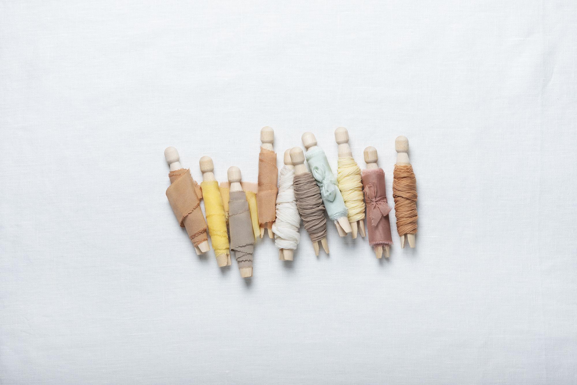 Close-up pastel thread palette and needle